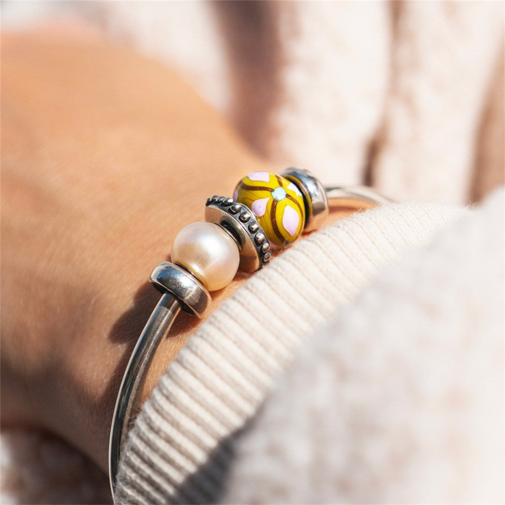 Close-up of a bracelet with beads on a blurred natural background