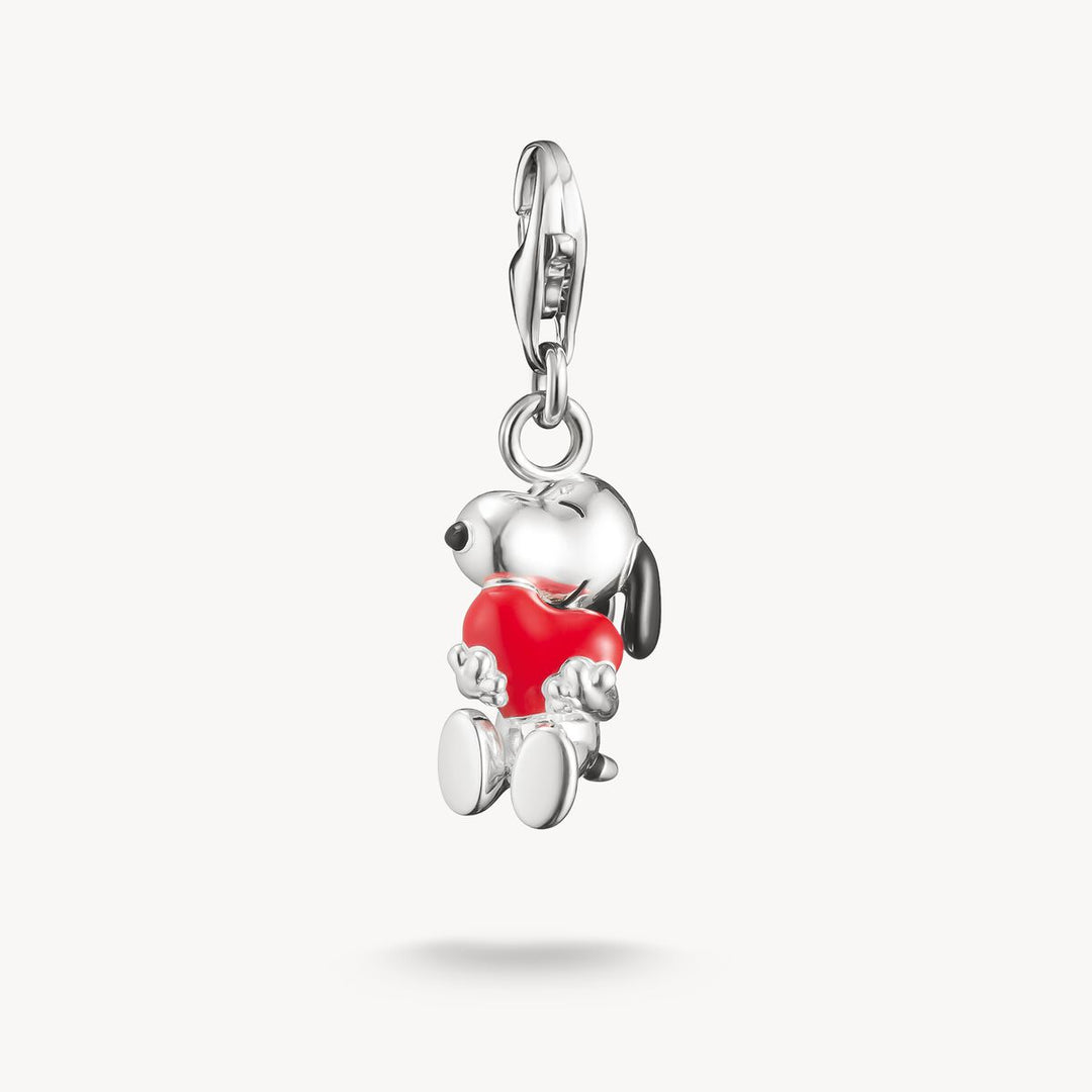 Silver dog charm with red heart on a white background