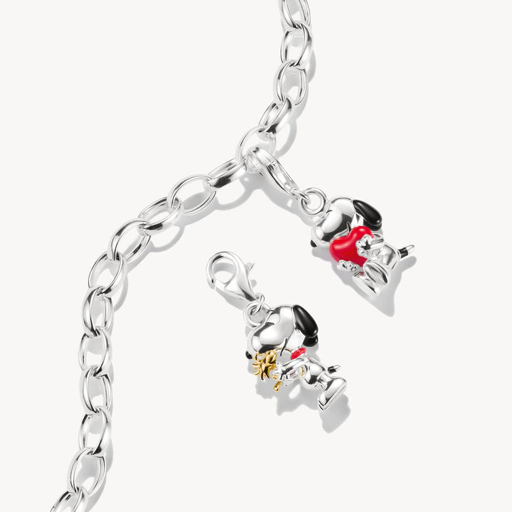 Silver bracelet with two charms on a white background