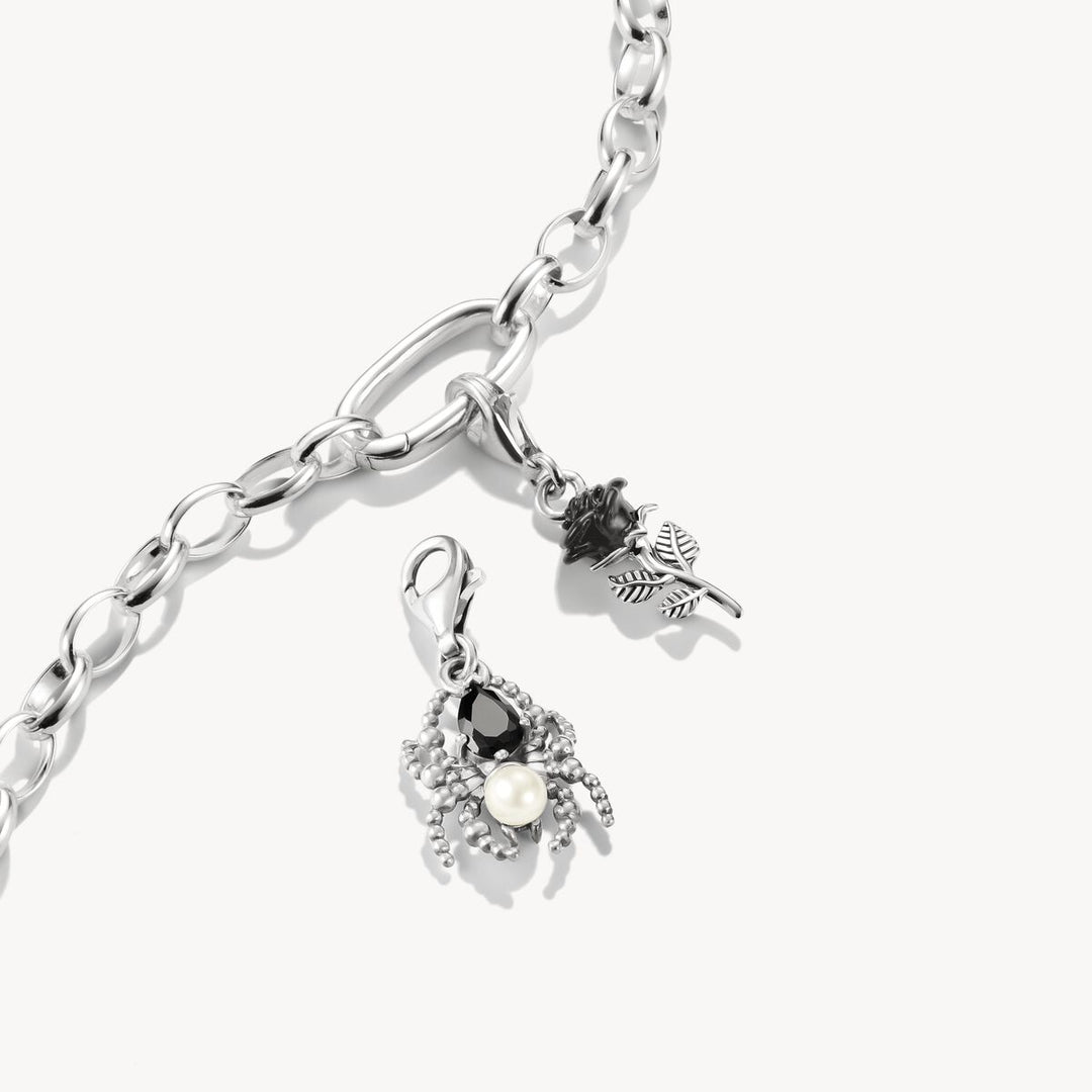 Silver bracelet with two charms on a white background