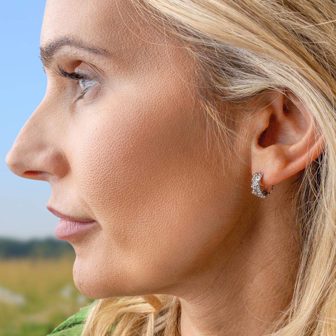 Close-up of a woman's profile with a blurred natural background