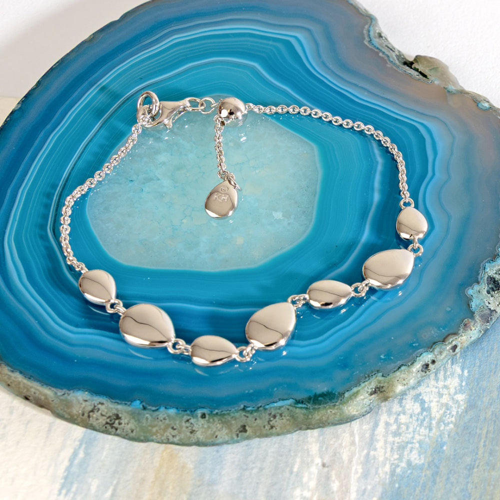 Silver bracelet with leaf-shaped beads on a blue agate stone