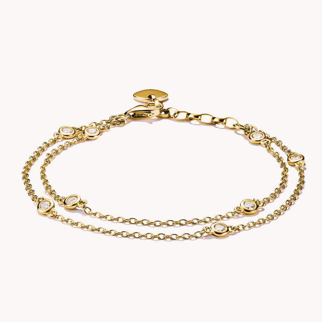 Gold bracelet with small heart charms on a white background