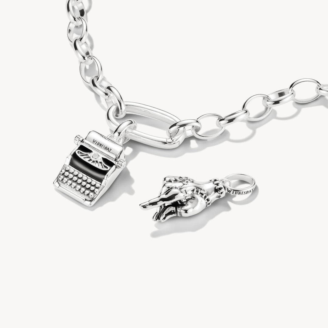 Silver bracelet with typewriter and horse shoe charm on a white background