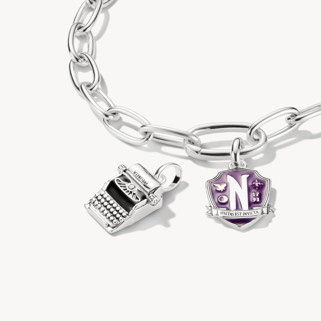 Silver bracelet with two charms on a white background