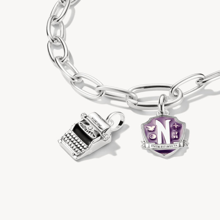 Silver bracelet with two charms on a white background