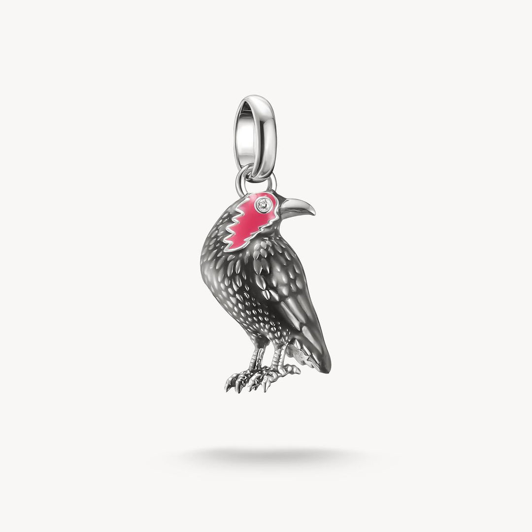 Silver bird-shaped pendant with red accents on a white background
