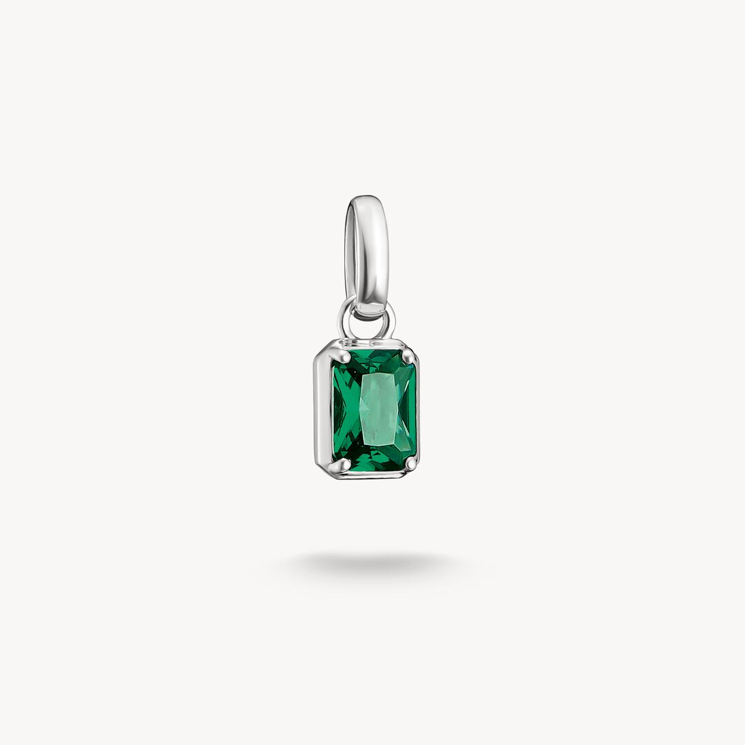 Silver pendant with a green gemstone on a white background