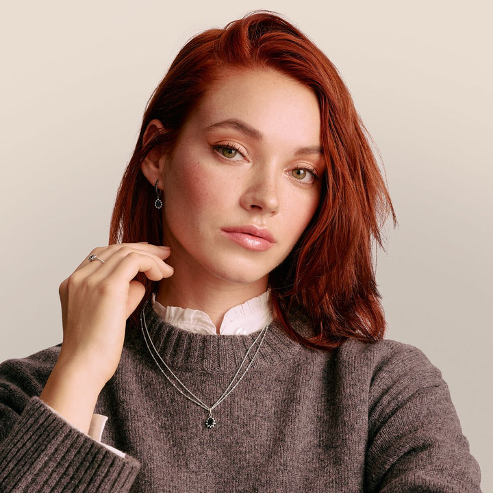Woman wearing a gray sweater with a neutral background
