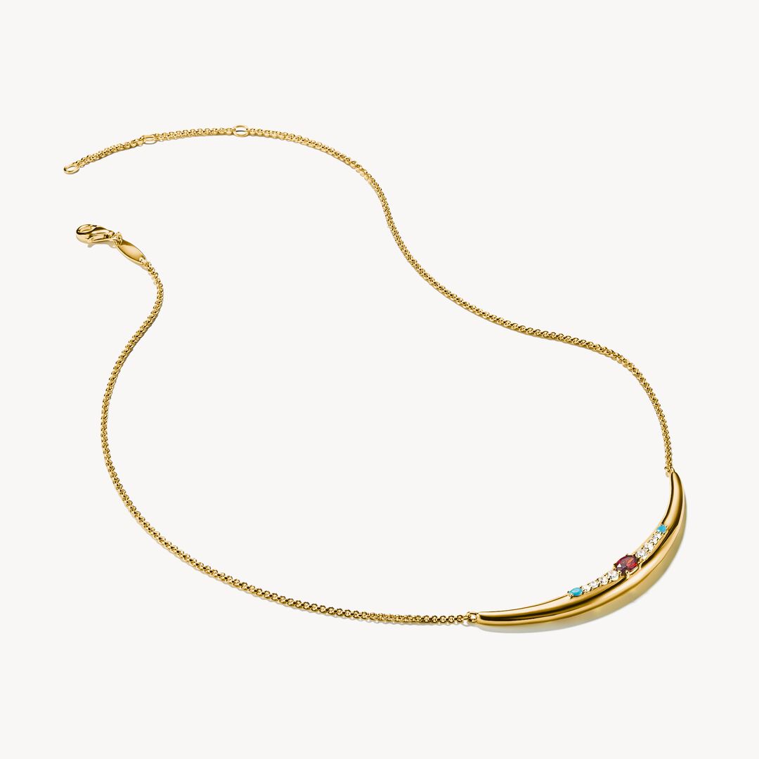 Gold necklace with gemstones on a white background