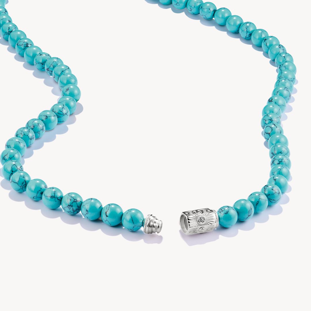 Turquoise beaded necklace with a silver clasp on a white background