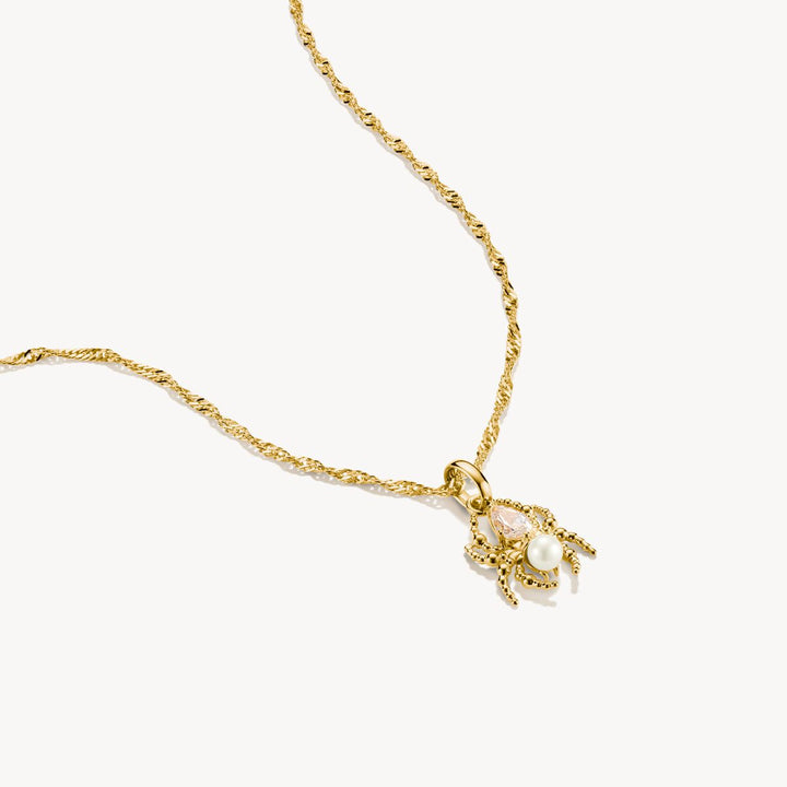 Gold necklace with a delicate pendant on a white background