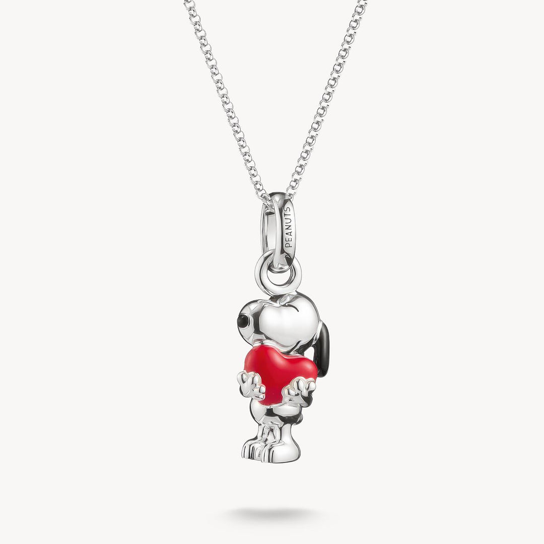 Silver pendant shaped like a dog with a red heart on a white background