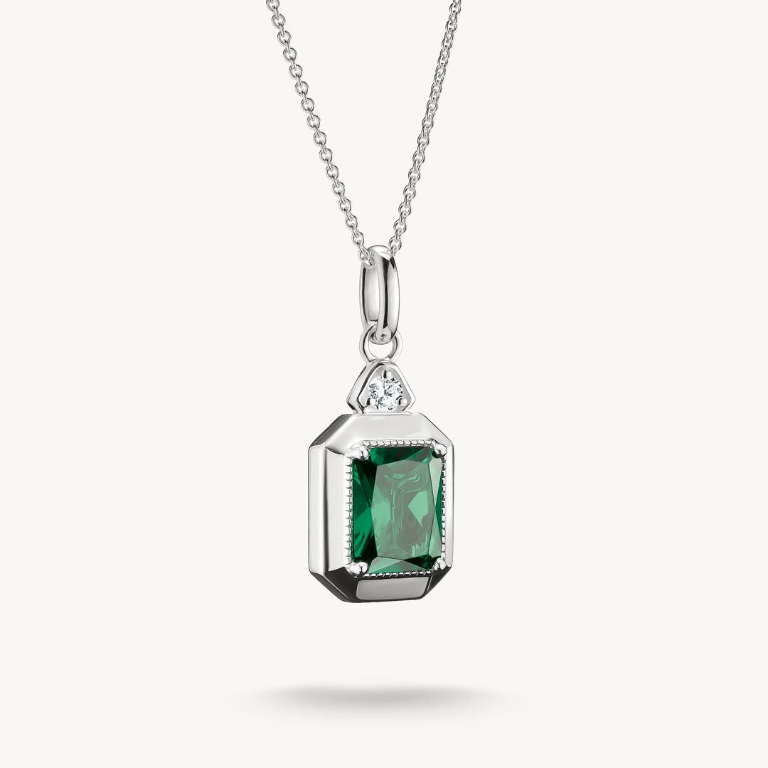 Silver pendant with green gemstone on a white background