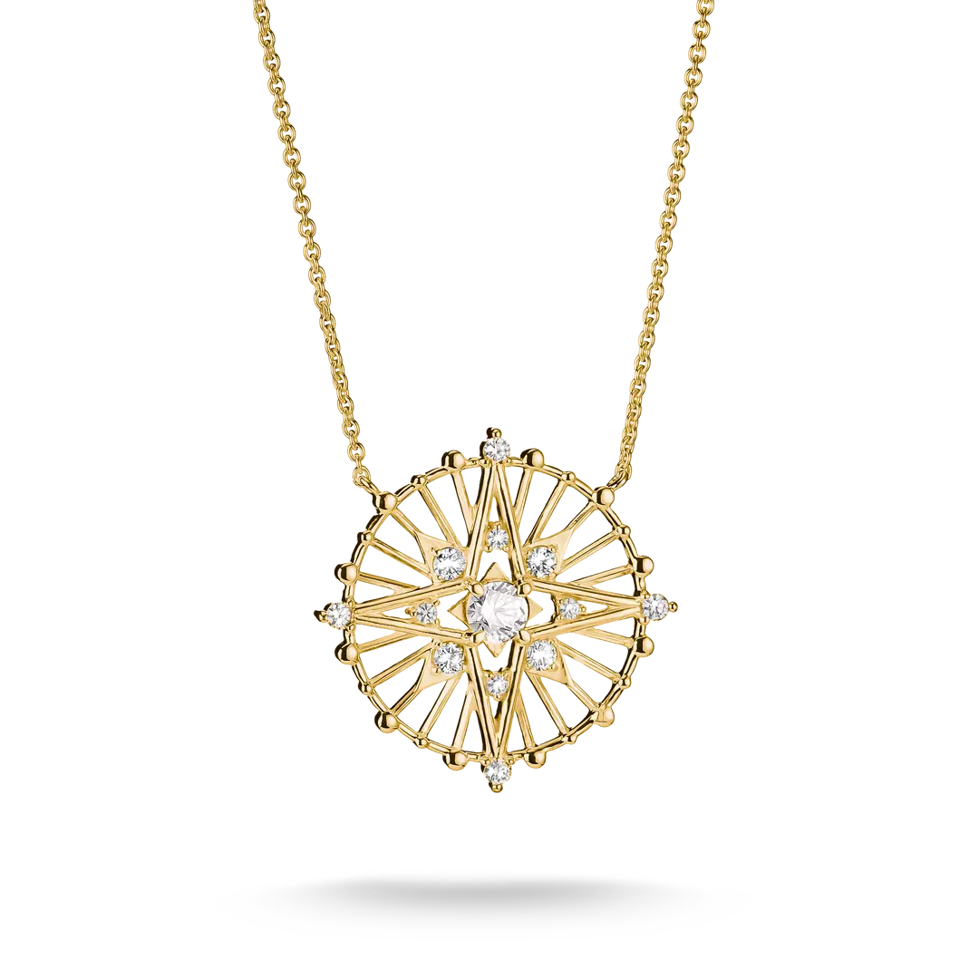 A gold pendant necklace featuring a circular sunburst design with clear gemstones, suspended from a delicate gold chain against a white background.