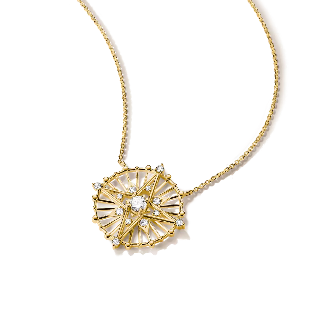 A gold necklace with a circular sunburst pendant featuring clear gemstones, shown on a clean white background.