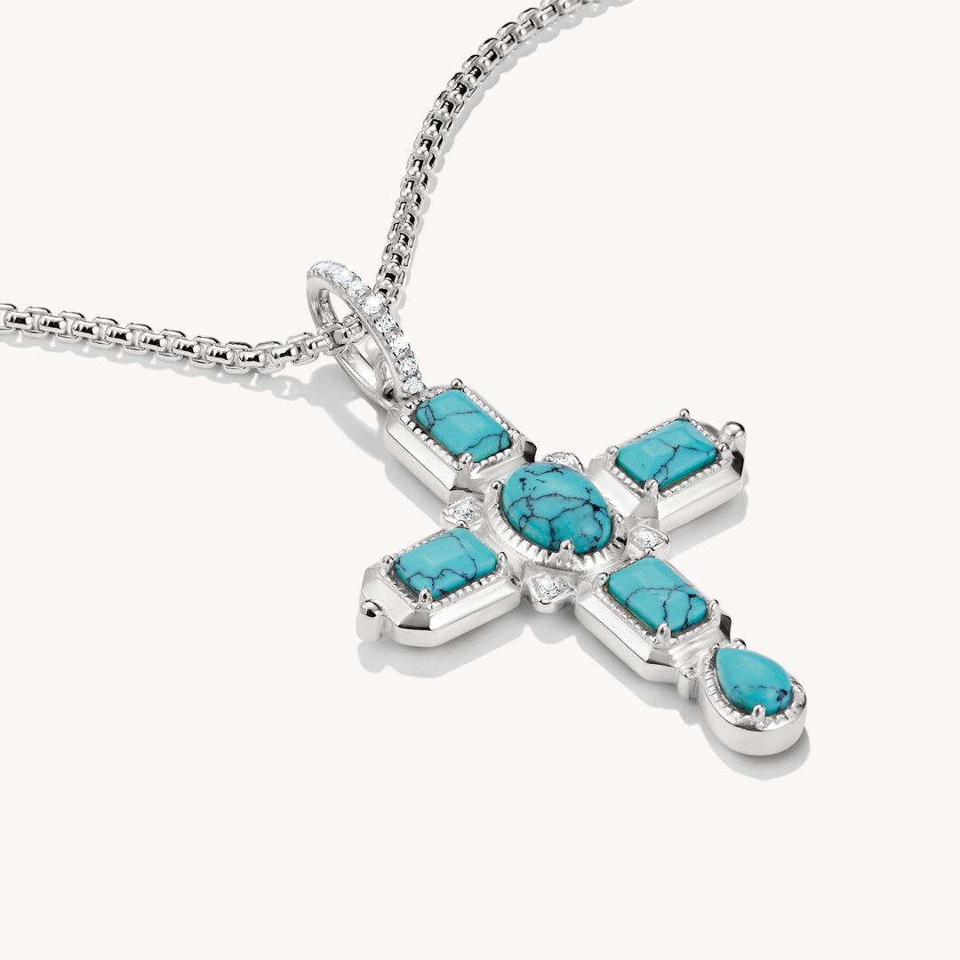 Silver cross pendant with turquoise stones on a white background