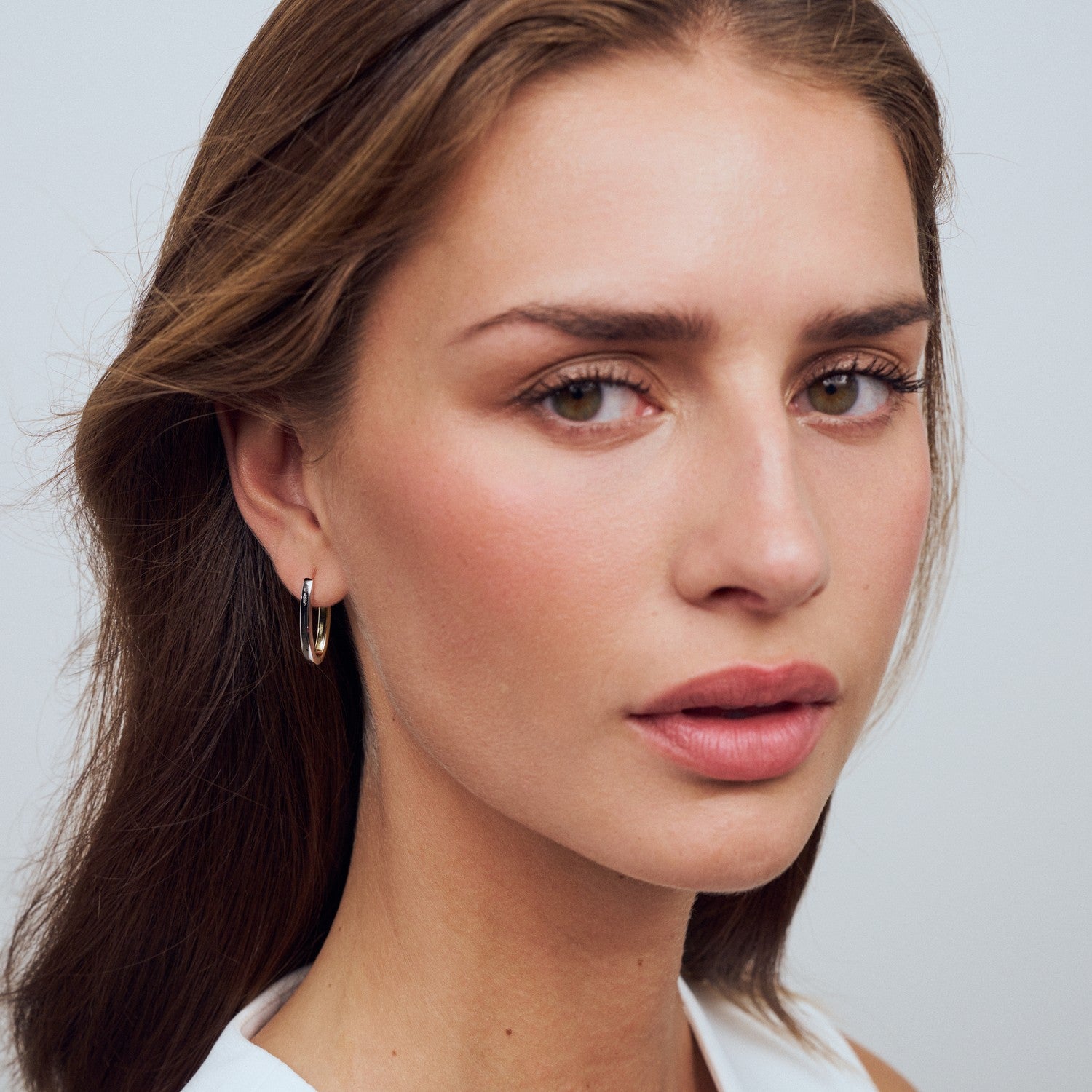 Close-up of a woman with a neutral expression on a plain background