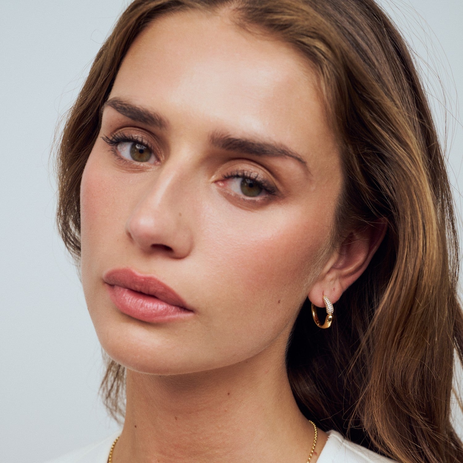 Close-up of a woman with a neutral expression on a plain background