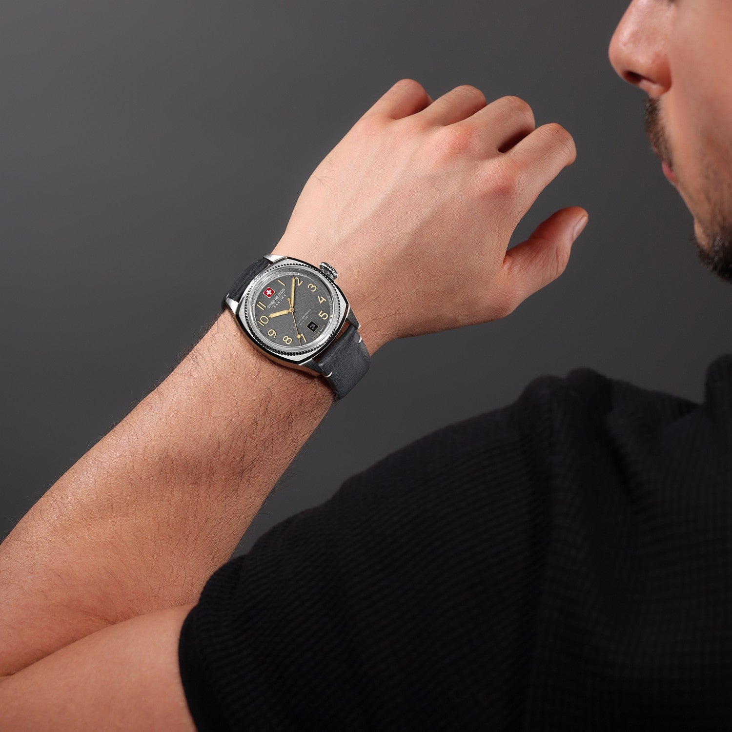 Man wearing a wristwatch on a dark background