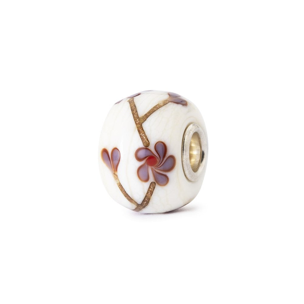 Decorative bead with floral design on a white background