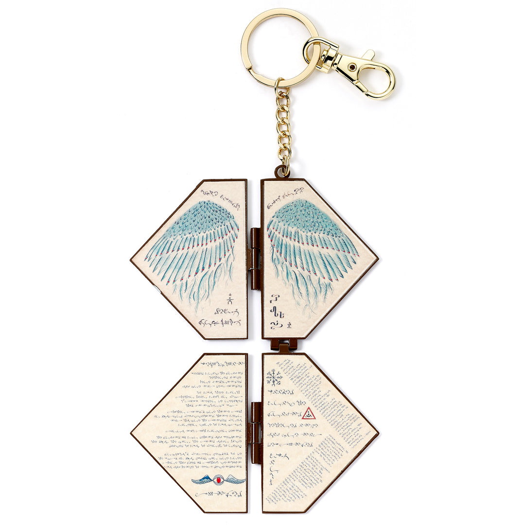 Hexagonal keychain with angel wings design on a white background