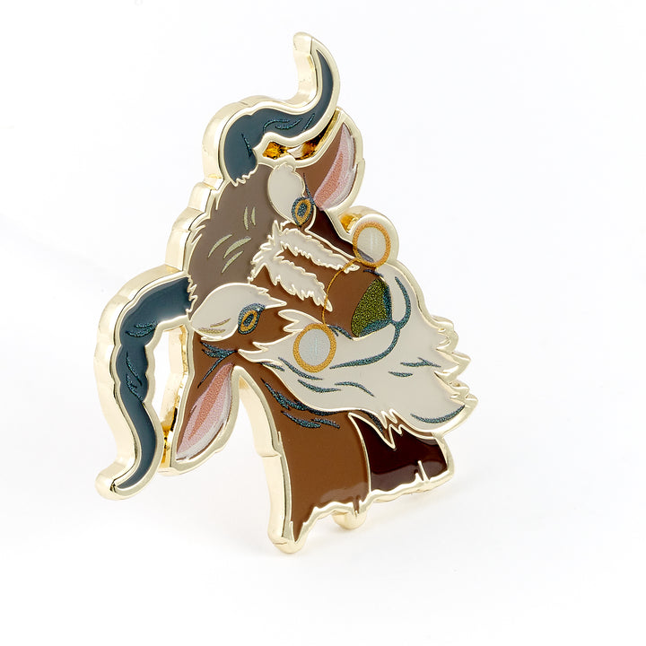 Enamel pin of a stylized creature with brown, white, and blue colors on a white background