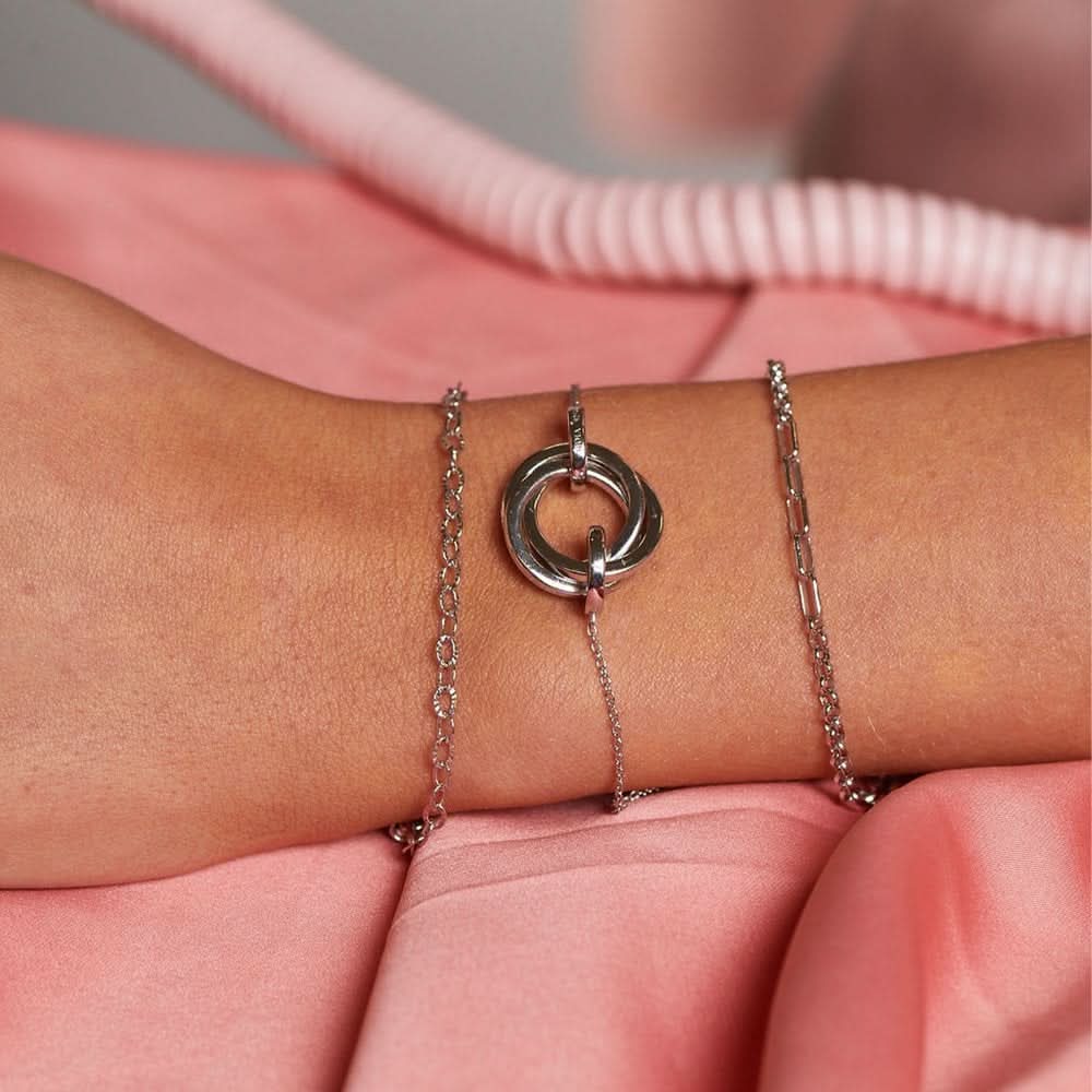 Stylish display of the sterling silver diamond cut oval bracelet on a wrist, paired with other silver bracelets, highlighting versatility and luxury.