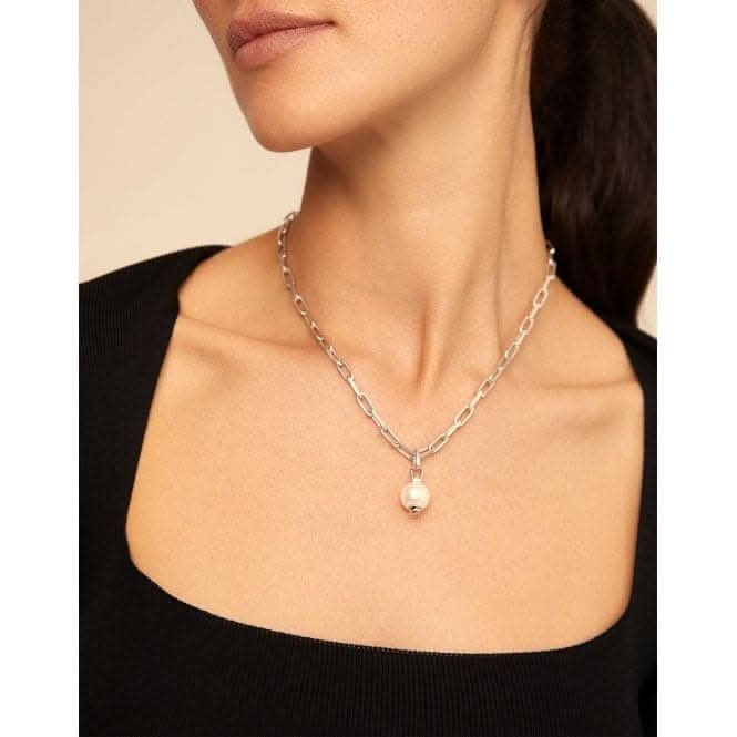 a woman wearing a necklace with a pearl on it