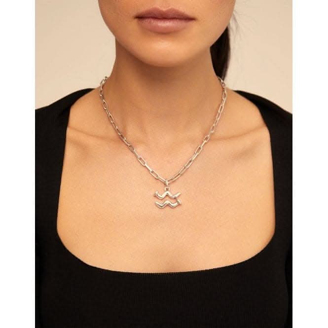 a woman wearing a necklace with two letters on it