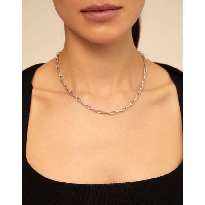 a woman wearing a black top and a silver chain necklace