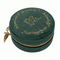 A round green velvet jewelry box with gold embroidered 'The Lord of the Rings' script and a gold zipper, featuring a small leaf-shaped charm on the side, set against a plain white background.