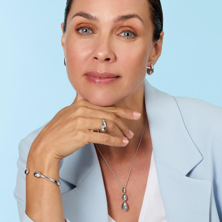 Woman wearing a necklace with a light blue background