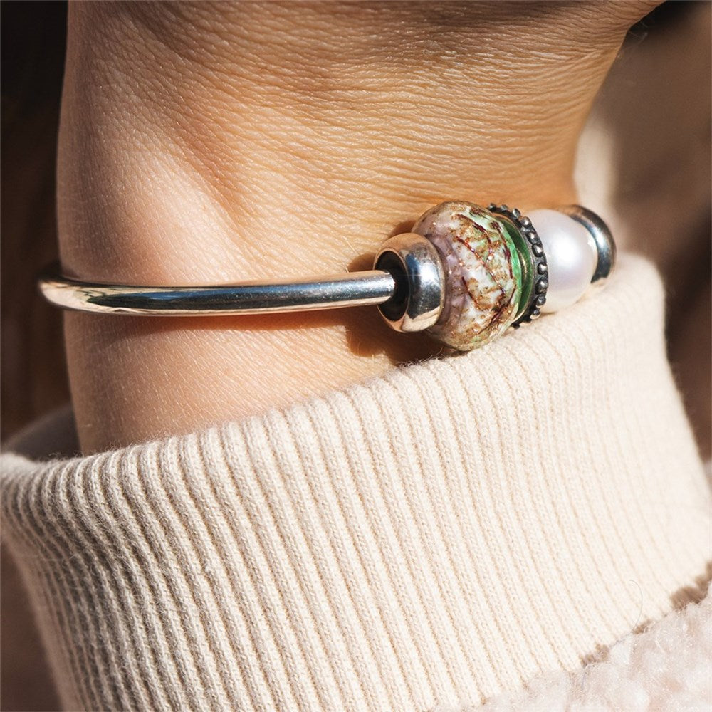 Close-up of a bracelet with decorative beads on a person's wrist.