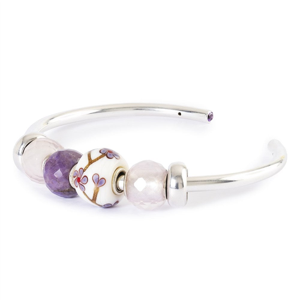 Silver bracelet with three beads on a white background