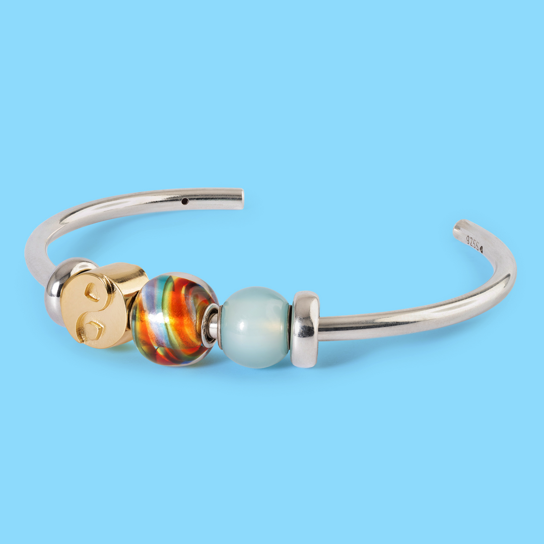 Silver bracelet with colorful beads on a light blue background