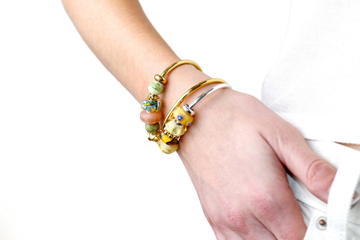 Close-up of a hand wearing multiple bracelets on a white background