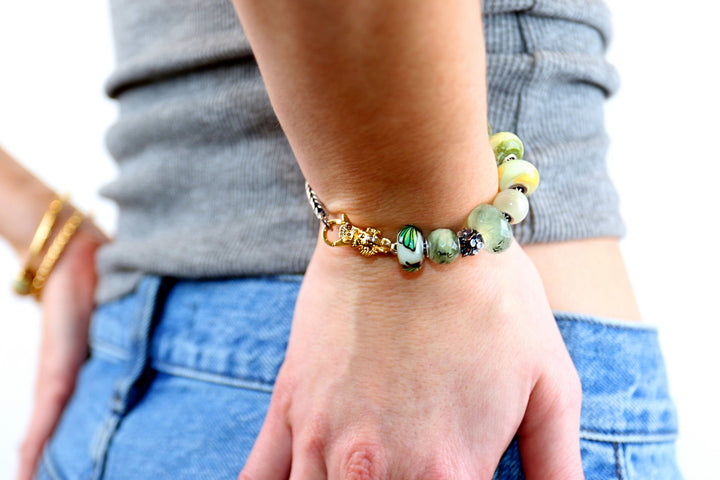 Person wearing a colorful beaded bracelet on a blurred background