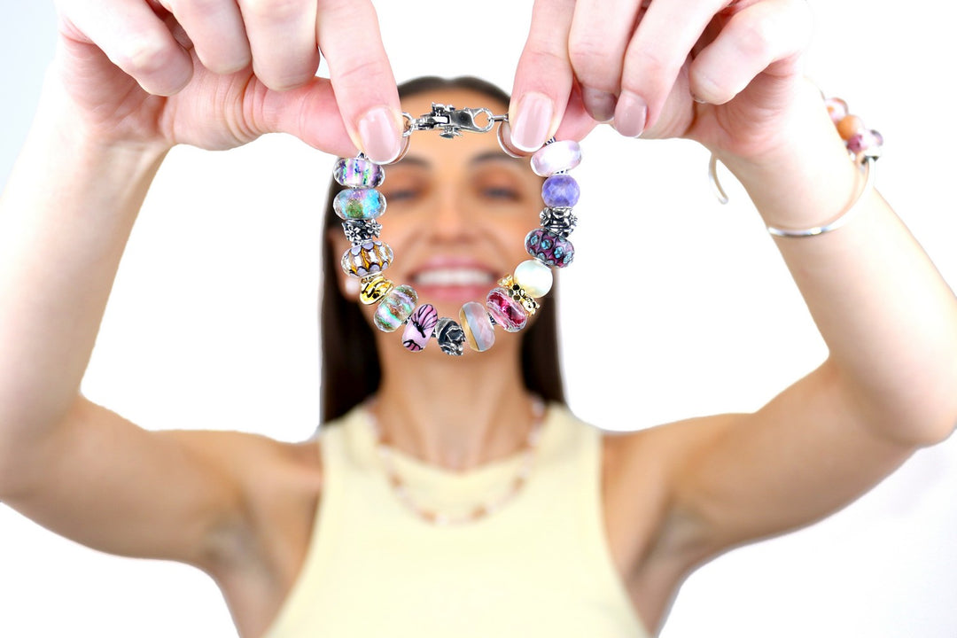 Woman holding a colorful beaded bracelet against a white background