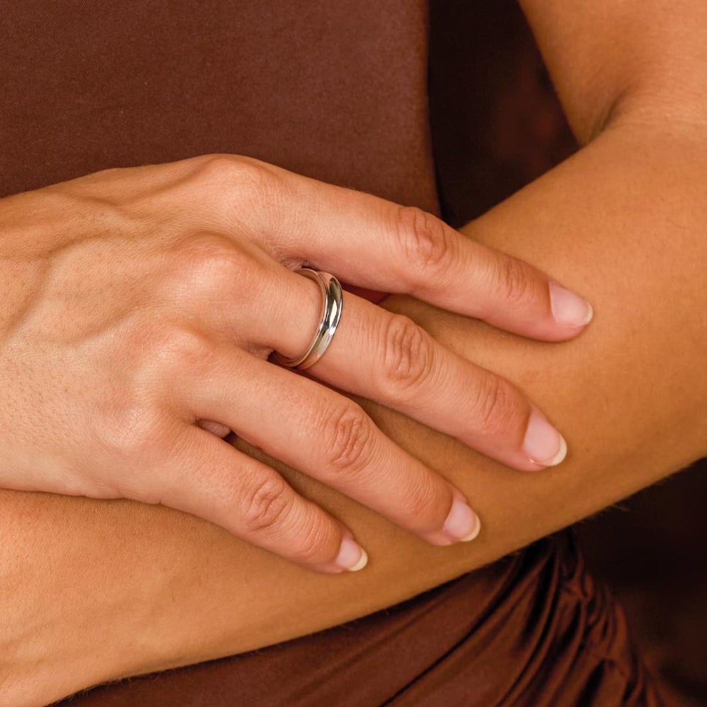 Close-up of a hand with a silver ring on a brown background