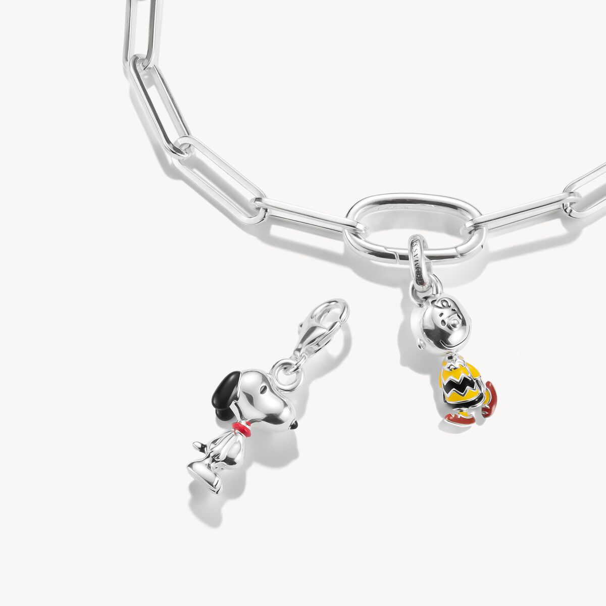 Silver dog charm with a red collar on a white background