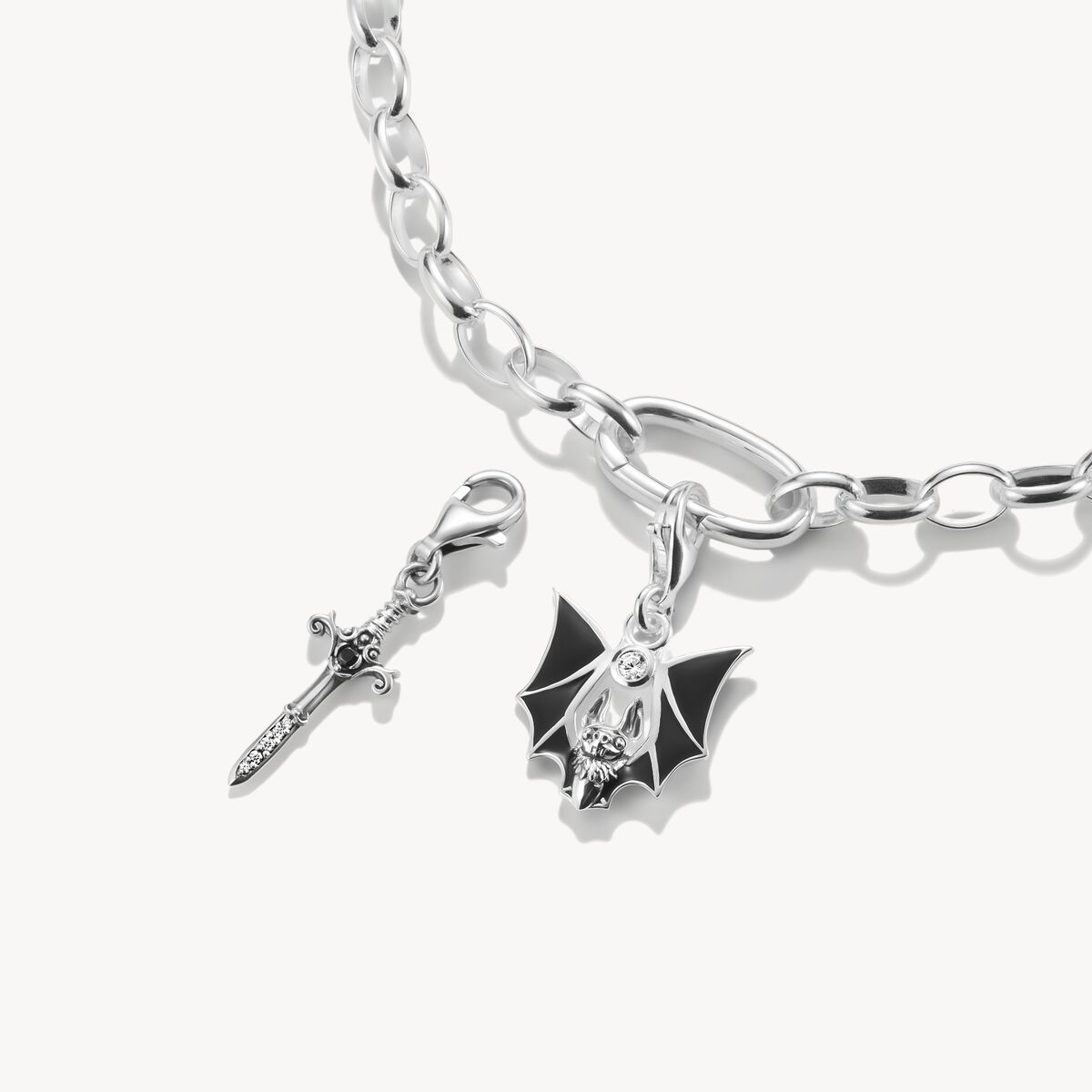Silver bracelet with two charms on a white background