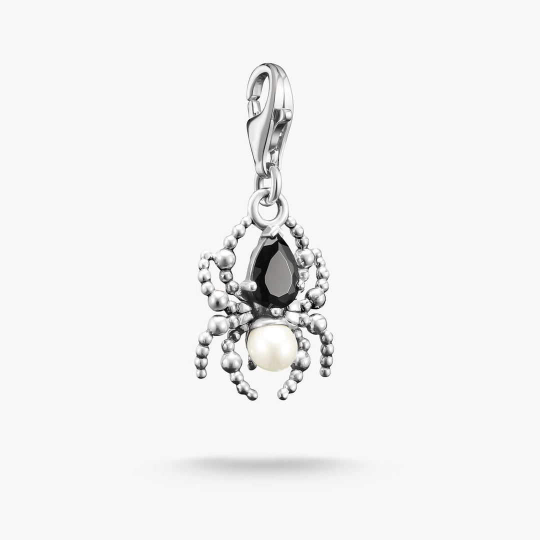 Jewelry pendant with black gemstone and pearl on a white background