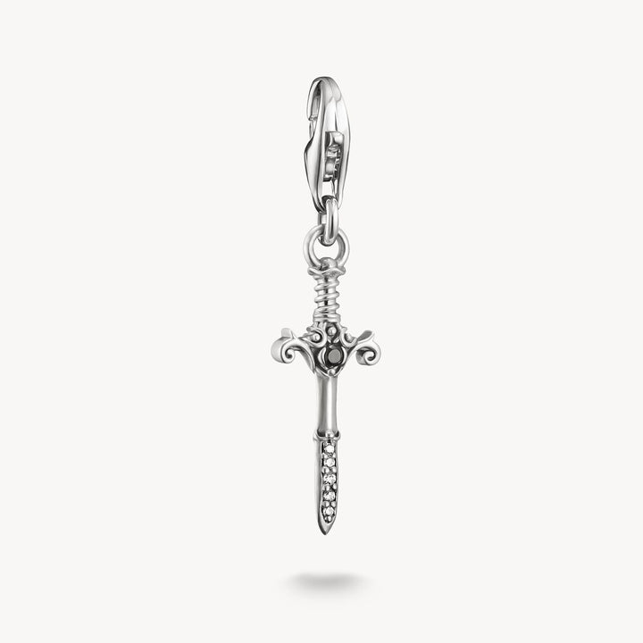 Silver sword-shaped charm on a white background