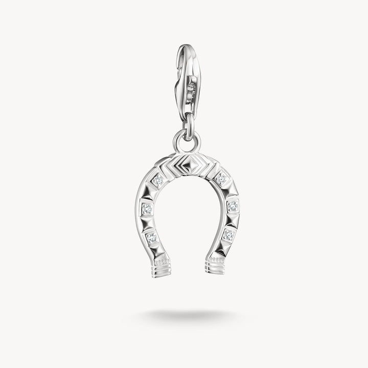 Silver horseshoe charm with embedded stones on a white background