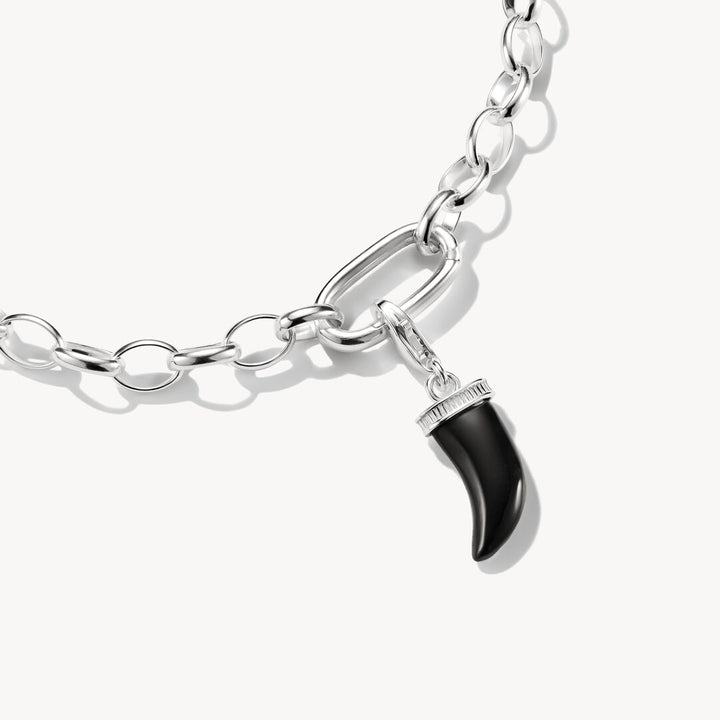Silver chain bracelet with a black horn charm on a white background
