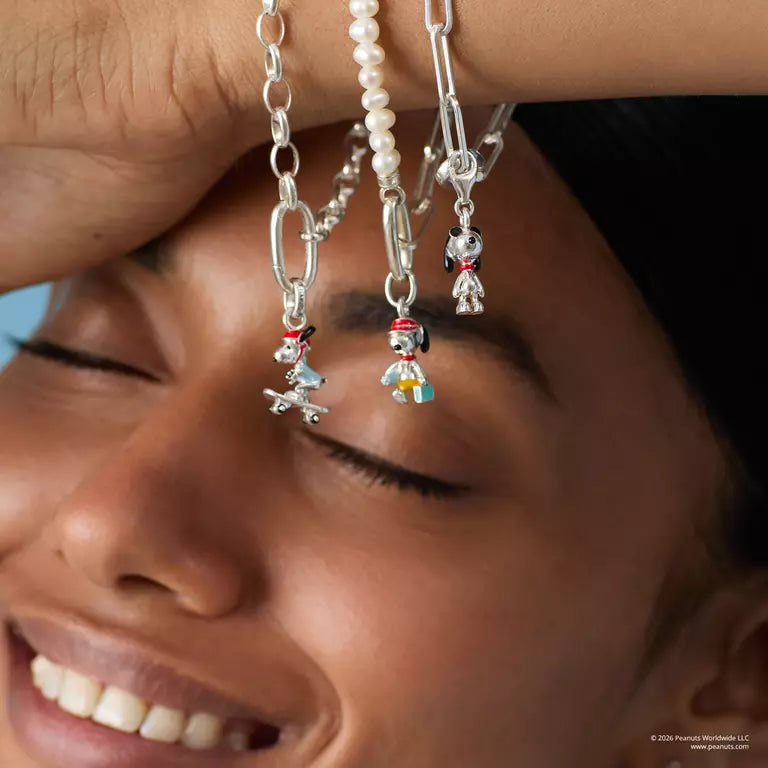 Close-up of a woman's face with three pairs of earrings hanging from her ears.