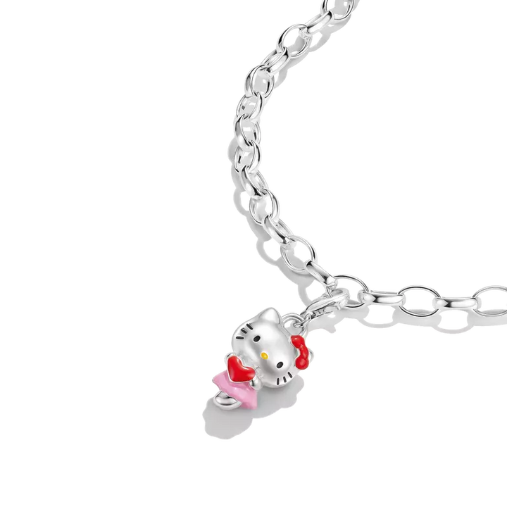 A silver-toned link chain necklace featuring a Hello Kitty charm with a pink dress, red bow, and yellow bow tie, shown on a clean white background.