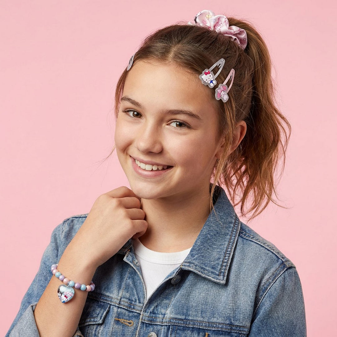 Young girl with decorative hair clips and a denim jacket on a pink background