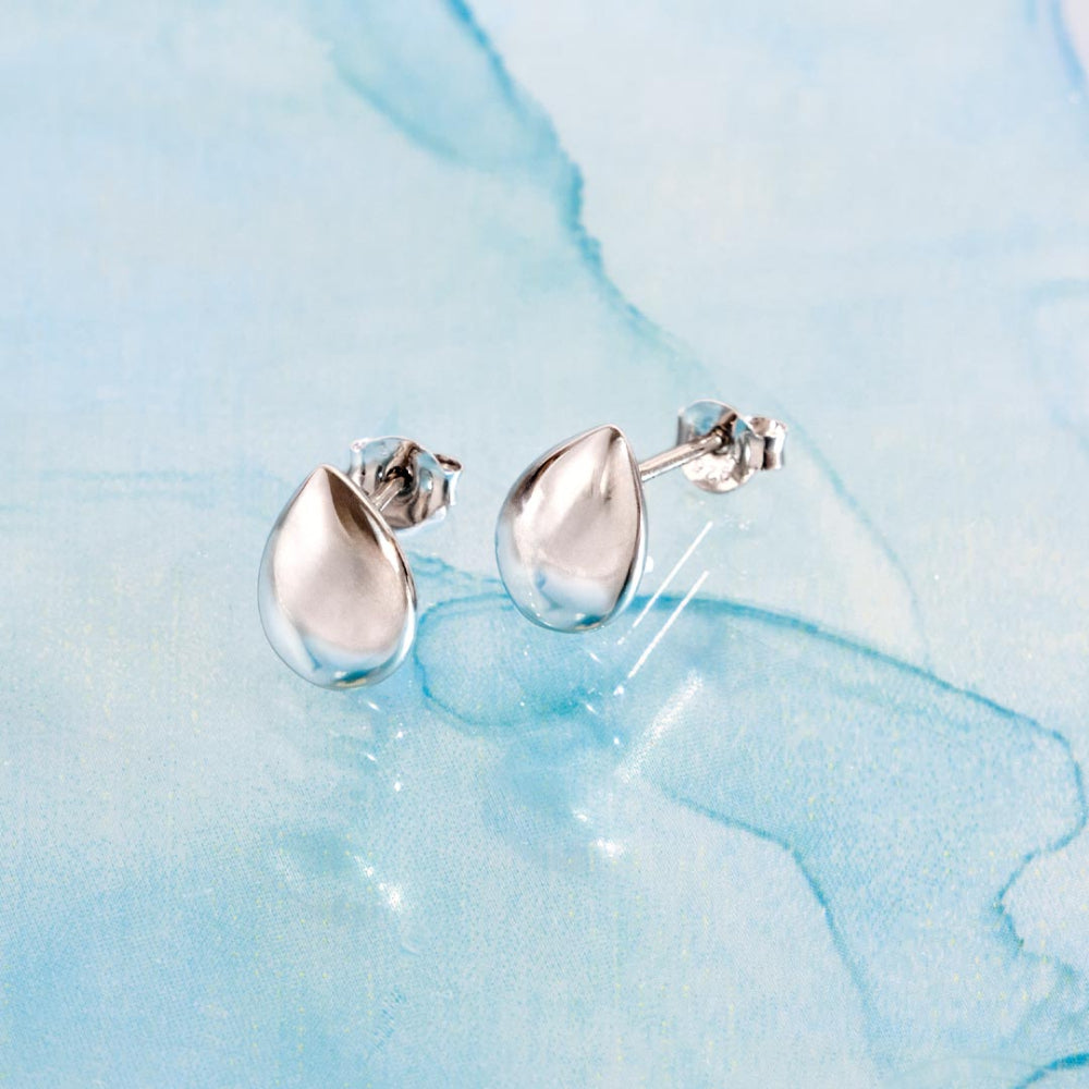 Silver teardrop earrings on a light blue marbled background